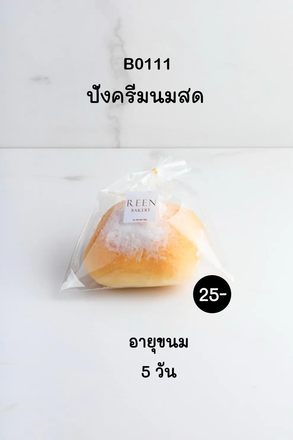 ขนมปังครีมนมสด 1 ชิ้น ลักษณะกลม เนื้อเหลืองทองนวล โรยหน้าด้วยผงนมขาวละเอียด บรรจุในถุงพลาสติกใสโปร่งแสง ผูกโบว์สีทอง และมีฉลากโลโก้ REEN Bak